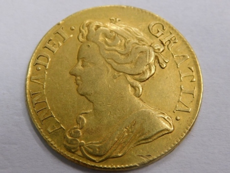 A Queen Anne gold guinea, 1714, crowned cruciform shield back.