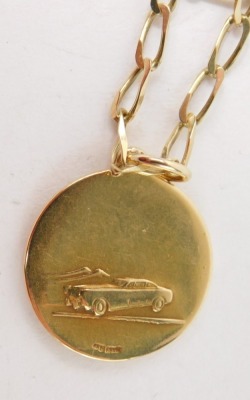 A St Christopher pendant and chain, the circular pendant with car model to reverse stamped 750 2½cm high, on a hammered curb link chain, 66cm long, yellow metal stamped 9kt, 8.4g all in - 3