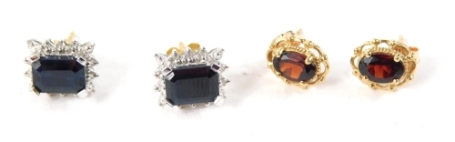 Two sets of 9ct gold stud earrings, comprising a pair of garnet clusters, with a pierced floral border, on butterfly backs, and a pair of rectangular cut sapphire and cz set cluster earrings, 3.4g all in. (2)