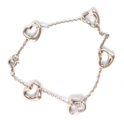 A silver bracelet, set with five love heart charms on a fine link chain, stamped 925, in Tiffany and Co box, 11cm long, 4.8g all in.