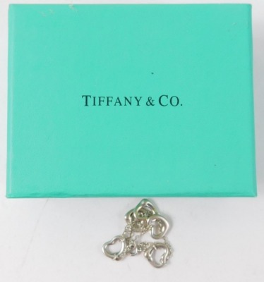 A silver bracelet, set with five love heart charms on a fine link chain, stamped 925, in Tiffany and Co box, 11cm long, 4.8g all in. - 3