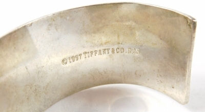 A silver bangle, inscribed New York, number 1002, stamped 1997, 7cm wide, 53g all in, in Tiffany and Co. box. - 3