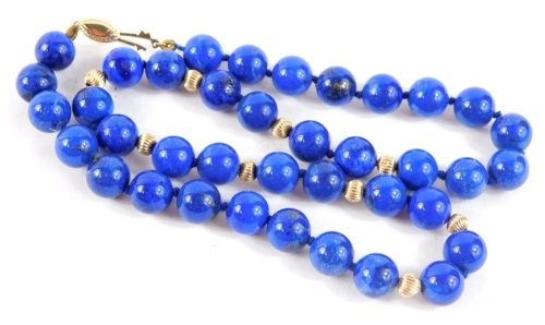 A lapis lazuli necklace, with blue string strand, and yellow metal bulbous beads, with sliding marcasite shaped clasp, yellow metal unmarked, 42cm long.