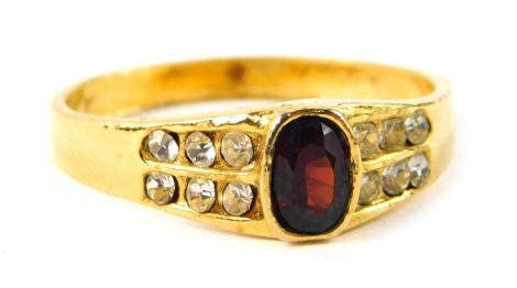 A dress ring, set with red and white paste stones, on a plated band, ring size U.