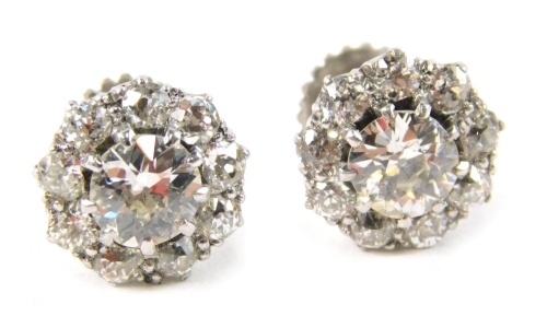 A pair of diamond cluster earrings, each with an old cut diamond centre, in an eight claw setting, approx. 0.61ct, surrounded by 9 old cut diamonds each approx. 0.05ct, in a white gold setting, with screw on backs, unmarked, 3.g all in.