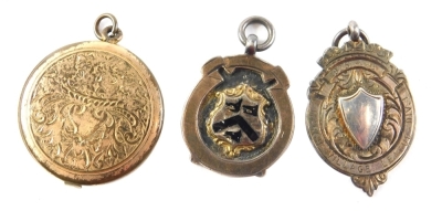 A silver and yellow metal fob, marked Marsh Village League Division One, a photograph frame pendant, 3cm diameter, and a silver and silver gilt fob medallion, The Bellamy Cup 1921-2. (3)