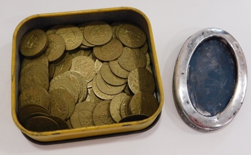 Various George III style plated guinea tokens, shield backs, contained in a Wills cut tobacco tin, 9cm wide, and a silver oval frame. (a quantity)