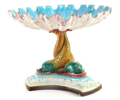 A 19thC Kerr & Binns Worcester Majolica centrepiece, with shell shaped bowl on pedestal formed by three entwined dolphins and a triform base, raised with a floral decoration, moulded mark to base, 15cm high.