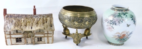 A Chinese bronze finish censer bowl, raised with a banding of scrolls and flowers, with an upper cross decoration, on a removable tricorn base, with elephant supports, unmarked, 19cm high, a pottery figure of a cottage, and a floral vase. (a quantity)