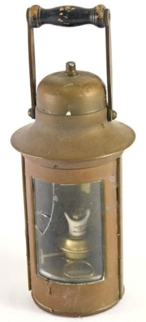 A 20thC brass ships lantern, with domed lid and swing handle, with shaped glazed front and candle holder, the main body 25cm high.