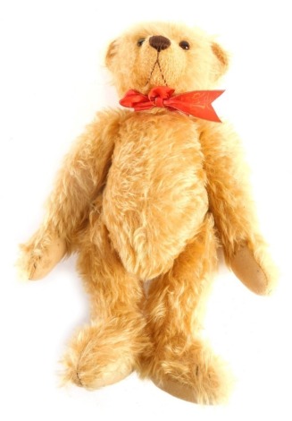 A 20thC Deans Frank Webster plush jointed teddy bear, with glass eyes, embroidered nose and mouth, with red ribbon to the neck, labelled. 39cm high.