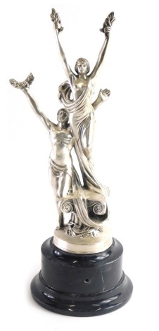 An early 20thC continental silvered metal figure group, in the manner of WMF formed as a lady and gentleman, each dressed in flowing robes on a socle, unmarked 36cm high,