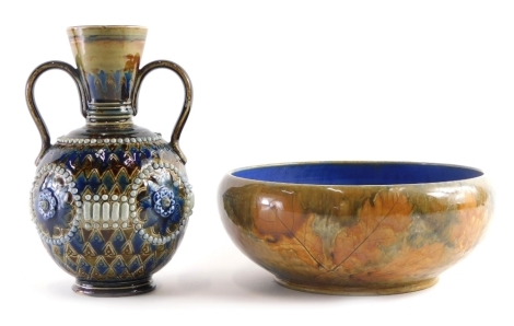 An early 20thC Royal Doulton Lambeth two handled vase, with raised floral and bead decoration with a sgrafitto diamond decoration, with impressed marks beneath, 22cm high, and a stoneware leaf decorated bowl, No. X853173868, impressed marks beneath. (2)