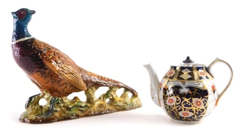 A Bewsick pottery figure of a pheasant 1225, impressed marks beneath, 20cm high and a J M Macintyre teapot in Imari pattern. (2)