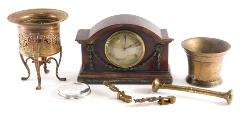 An early 20thC mahogany cased mantel clock, with raised garland decoration, the domed front revealing a 9cm diameter Roman numeric dial, on compressed orb feet, with a brass pestle and mortar and an elaborate brass planter, part travelling sovereign scale