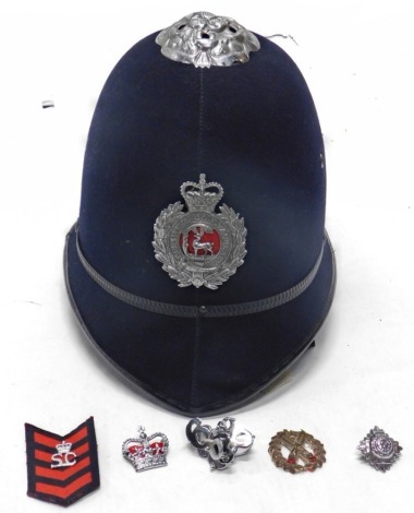 A Berkshire constabulary police helmet, with metal badge, various other police badges.