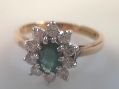 An emerald and diamond cluster dress ring