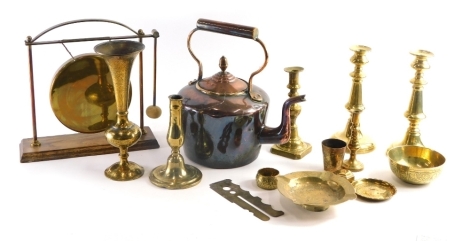 Various metalware, an early 20thC brass dinner gong, early 20thC copper kettle, 35cm high, various candlesticks, etc. (a quantity)