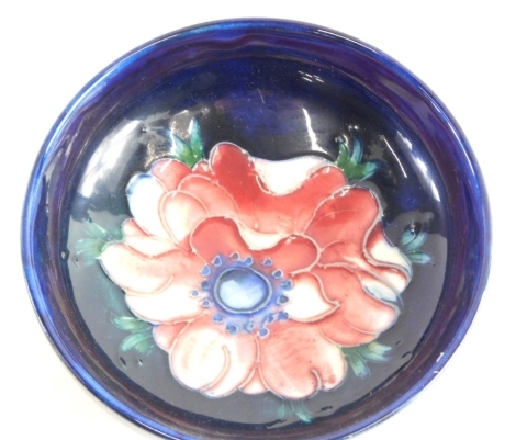 A mid 20thC Moorcroft pottery Anemone pattern bowl, on blue ground, Queen Mary label and marks beneath, 12cm diameter.