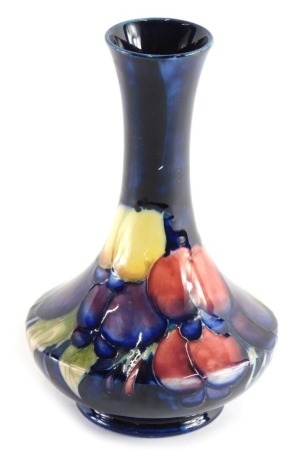 A mid 20thC Moorcroft Plum pattern vase, with inverted stem, bellied body and circular foot, on blue ground, impressed marks and signature mark beneath, 17cm high.