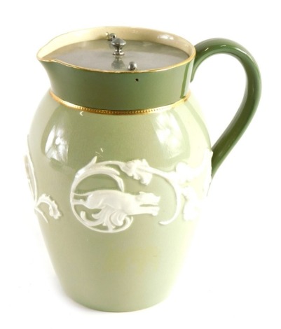 An unusual early 20thC James Macintyre Washington Faience jug, with beak spout, plain handle, gilt highlights and raised floral pattern to the green ground, printed marks beneath, 19cm high.