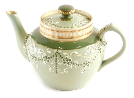 A Macintyre Faience pattern teapot, with a raised floral decoration to the green ground, marks beneath, 14cm high,