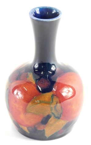 A Moorcroft Pomegranate vase, on circular foot, impressed marks beneath, on blue ground, 10cm high.