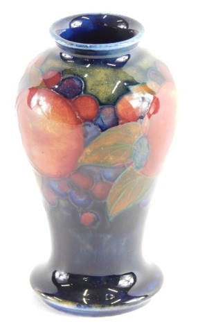 A Moorcroft Pomegranate pattern vase, of inverted circular form with circular foot, impressed marks beneath, 11cm high.