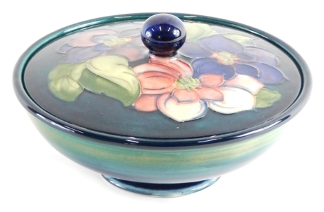 A mid 20thC Moorcroft bowl and cover, on green ground, impressed marks and label beneath, 16cm diameter.